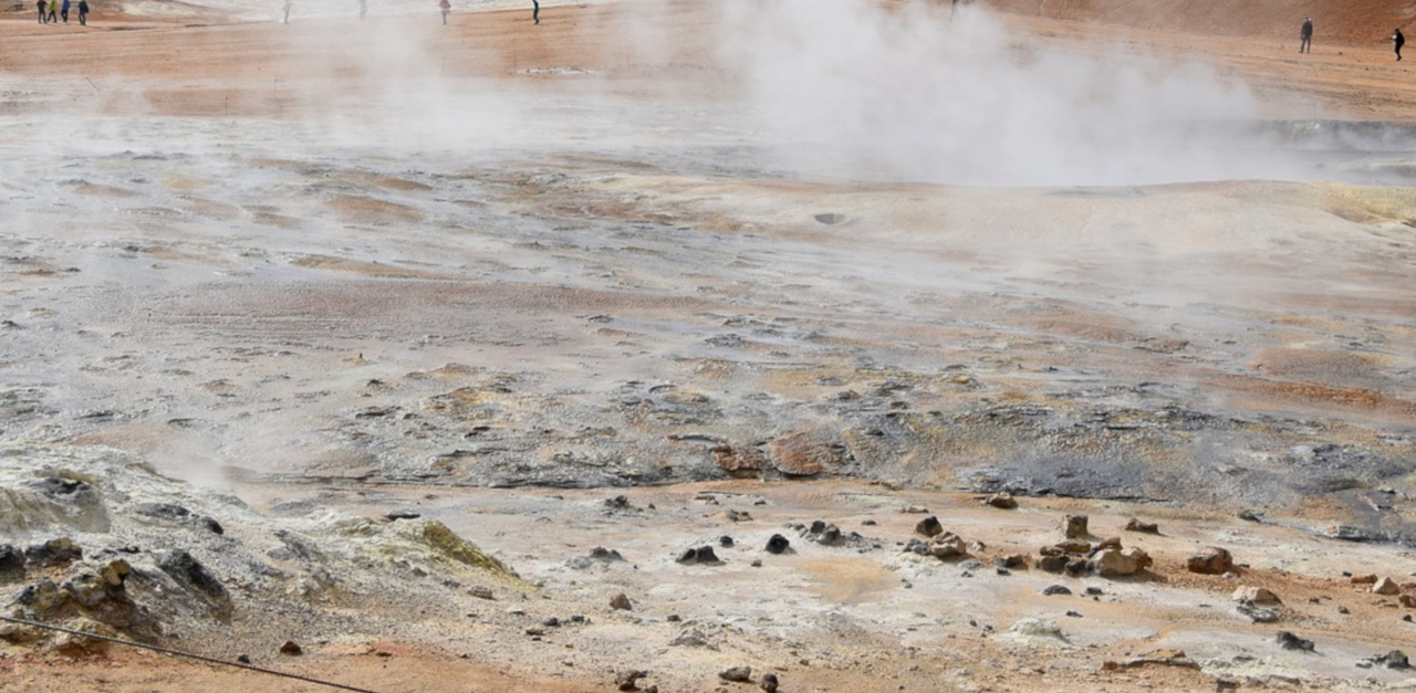 The image shows eight EU flags in front of the Berlaymont building in Brussels, which houses the headquarters of the EU commission.